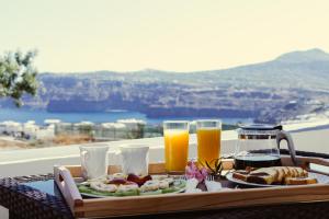 アクロティリにあるAnya Suites Santoriniの食品トレイとオレンジジュース2杯