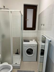 ein Badezimmer mit einer Waschmaschine und einem WC in der Unterkunft Apartment Tazzoli 11 in Carugo