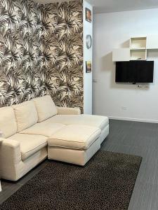 sala de estar con sofá blanco y pared en Apartment Tazzoli 11, en Carugo