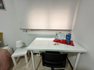阿利坎特的住宿－Moderna habitación en el corazón de Alicante，一张白色的桌子,放在带椅子的房间里