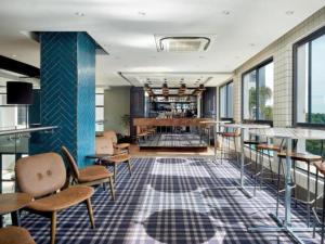 a lobby with tables and chairs and a bar at The Regency Aparthotel in Pretoria