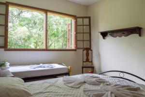 a bedroom with two beds and a window at Sítio da Vovó Dinha in Contagem