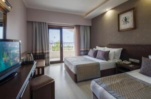 een hotelkamer met 2 bedden en een televisie bij Club Hotel Turan Prince World - Kids Concept in Kizilagac
