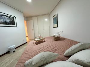 1 dormitorio con 1 cama grande con almohadas y mesa en Moderna habitación en el corazón de Alicante en Alicante