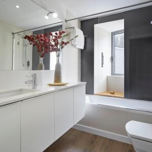 un bagno con armadi bianchi e un vaso con fiori di Val Arties 3 by FeelFree Rentals ad Arties