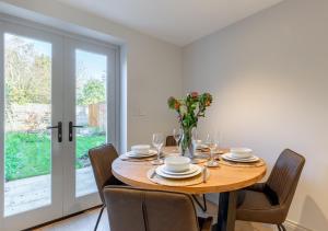 a dining room with a wooden table and chairs at Honeysuckle Cottage - Bramfield in Bramfield