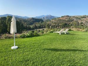 an umbrella and chairs in a field of grass at Casa Rustica en Marbella in Estepona