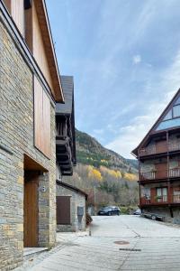 a group of buildings with a parking lot and a mountain at Val Arties 3 by FeelFree Rentals in Arties
