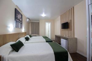 a hotel room with four beds and a television at Hotel Nacional Inn Curitiba Torres in Curitiba +53 photos