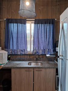 eine Küchentheke mit einem Waschbecken und einem Fenster in der Unterkunft Mini casa Contêiner em Bombas in Bombinhas