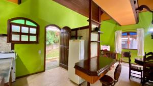 een keuken met groene muren en een koelkast bij Casa de Campo - Condomínio Arco Íris in Atibaia