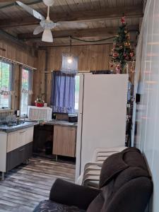eine Küche mit einem Weihnachtsbaum und einem weißen Kühlschrank in der Unterkunft Mini casa Contêiner em Bombas in Bombinhas