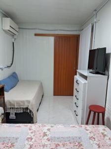1 dormitorio con 2 camas, TV y tocador en Mini casa Contêiner em Bombas en Bombinhas