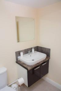 a bathroom with a white sink and a mirror at Charming 1-Bed Apartment in Stroud in Stroud