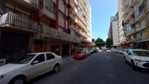 une voiture blanche garée sur le côté d'une rue de la ville dans l'établissement EfDepartamentos Plaza Colon con balcón a la calle, à Mar del Plata