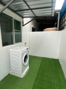 uma máquina de lavar roupa num quarto com relva verde em Aileen House em Chiang Mai