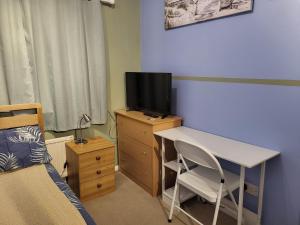 - une chambre avec un bureau, une télévision et un lit dans l'établissement educatefirst, à Christchurch