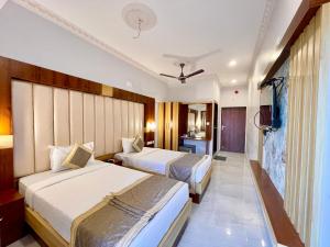 a hotel room with two beds and a television at Hotel A One Lagoon ! Puri Swimming-pool, near-sea-beach-and-temple fully-air-conditioned-hotel with-lift-and-parking-facility breakfast-included in Puri