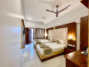a bedroom with two beds and a ceiling fan at Hotel A One Lagoon ! Puri Swimming-pool, near-sea-beach-and-temple fully-air-conditioned-hotel with-lift-and-parking-facility breakfast-included in Puri