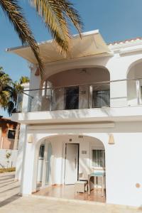 una casa blanca con una palmera en Casa Feliz - RentCar, en Calpe