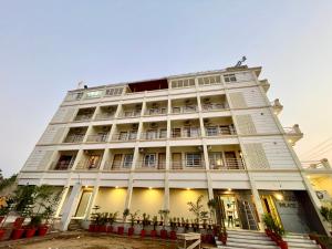 um grande edifício branco com muitas janelas em Hotel A One Lagoon ! Puri Swimming-pool, near-sea-beach-and-temple fully-air-conditioned-hotel with-lift-and-parking-facility breakfast-included em Puri
