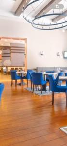 een eetkamer met blauwe stoelen en tafels bij Terra SP apartments-Razlog in Razlog