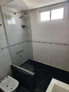 a bathroom with a shower and a toilet and a sink at Casagrande Centenario in Centenario