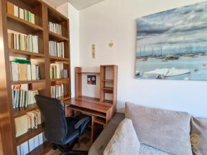 een bureau en een stoel in een kamer met boekenplanken bij Holiday House Srečka in Izola +26 foto's