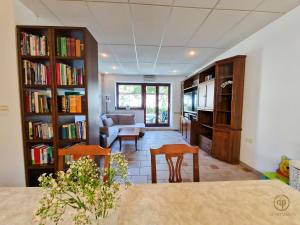 een woonkamer met boekenplanken en een tafel en stoelen bij Holiday House Srečka in Izola