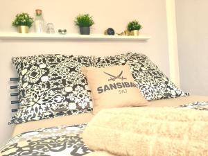a bed with a samedan pillow on top of it at Studio St. Gereon (central & cozy) in Cologne