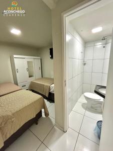 a hotel room with two beds and a toilet at Hotel Aconchego Cearense in Fortaleza