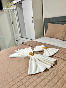 ein Schlafzimmer mit zwei weißen Handtüchern auf einem Bett in der Unterkunft Hotel Aconchego Cearense in Fortaleza