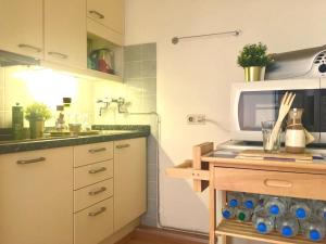 a kitchen with a sink and a microwave at Studio St. Gereon (central & cozy) in Cologne