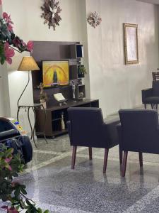 uma sala de estar com mesa e cadeiras em Hotel Maria da Fé em Aparecida