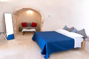 a bedroom with a bed and a couch in a room at Masseria Dirupo in Noci