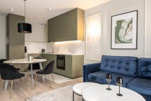 salon z niebieską kanapą i kuchnią w obiekcie RentPlanet - Apartament Ślężna we Wrocławiu