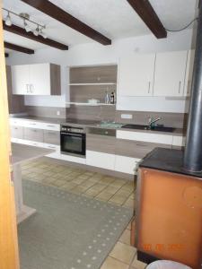 a kitchen with white cabinets and a black counter top at Pension Anderl in Bodenmais