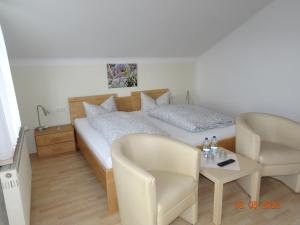 1 dormitorio con 1 cama, mesa y sillas en Pension Anderl, en Bodenmais