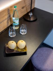 deux bottes sur une assiette avec deux verres et une bouteille dans l'établissement NASHI Rooms, à Erfurt