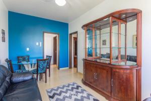 - un salon avec des murs bleus et une armoire en bois dans l'établissement Apto confortável Bem localizado em POA EBA0401, à Porto Alegre
