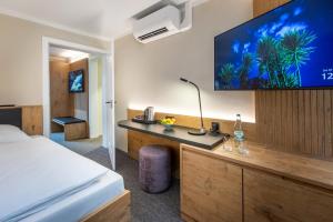 a hotel room with a bed and a flat screen tv at NASHI Rooms in Erfurt