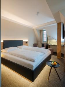 a bedroom with a large bed and a table at NASHI Rooms in Erfurt