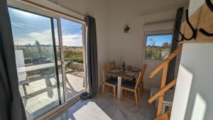 een kleine tafel en stoelen in een kamer met een raam bij Appartement au coeur des rizières in Salin-de-Giraud