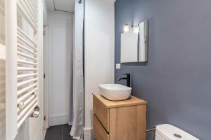 La salle de bains est pourvue d'un lavabo blanc et d'un miroir. dans l'établissement 4212 - AB Poble Sec, à Barcelone