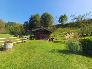 a log cabin in a field with a fence at Ferienhaus Lemberger in Jochberg