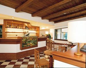 un restaurante con un bar con una pecera en RESIDENCE-RESORT BORGO AL SOLE en Sappada