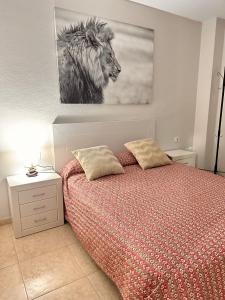 a bedroom with a bed and a picture of a lion at Céntrico apartamento de 2 dormitorios en La Laguna in Las Lagunas