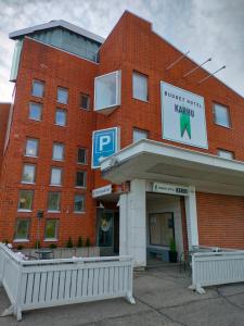 un edificio de ladrillo rojo con un cartel. en Budget Hotel Karhu, en Sodankylä