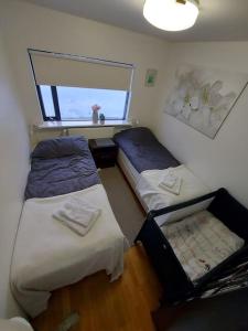 a small room with two beds and a window at Excellent location in Keflavík at Faxabraut 49. in Keflavík