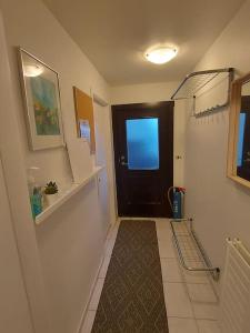 a hallway with a black door and a tile floor at Excellent location in Keflavík at Faxabraut 49. in Keflavík